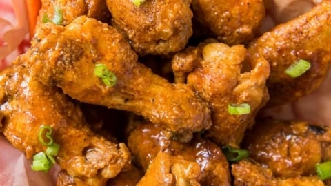 Basket of buffalo wings and carrot and celery sticks.