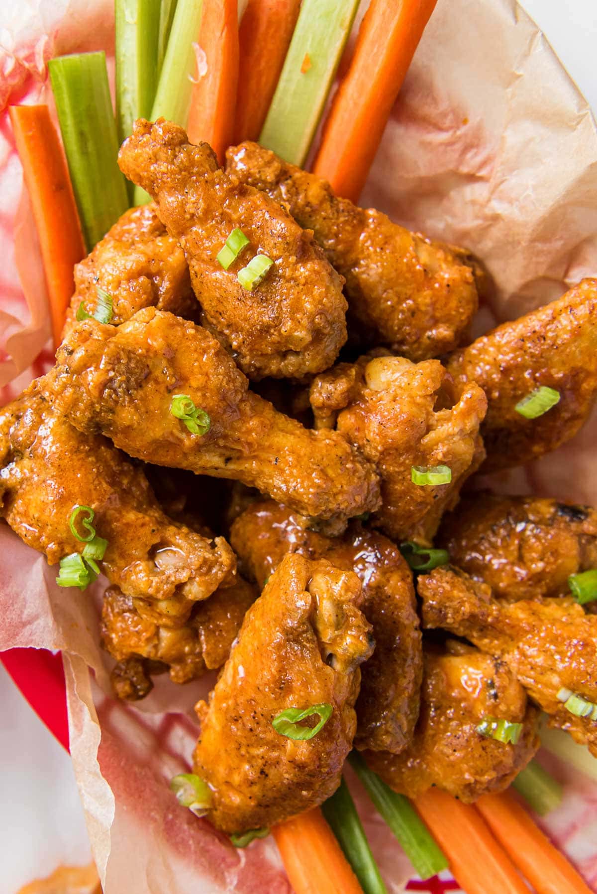 Basket of buffalo wings and carrot and celery sticks.