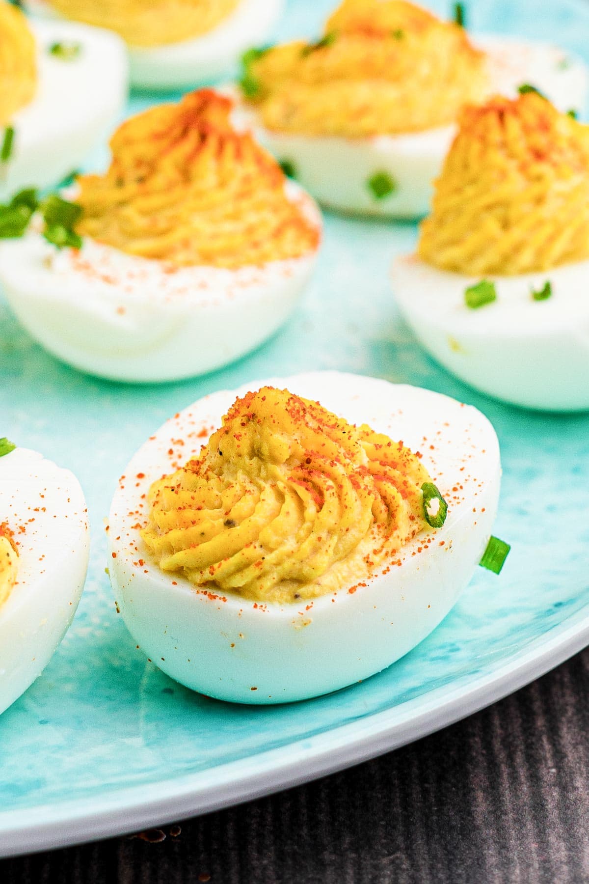 Close up of a deviled egg on a blue platter.