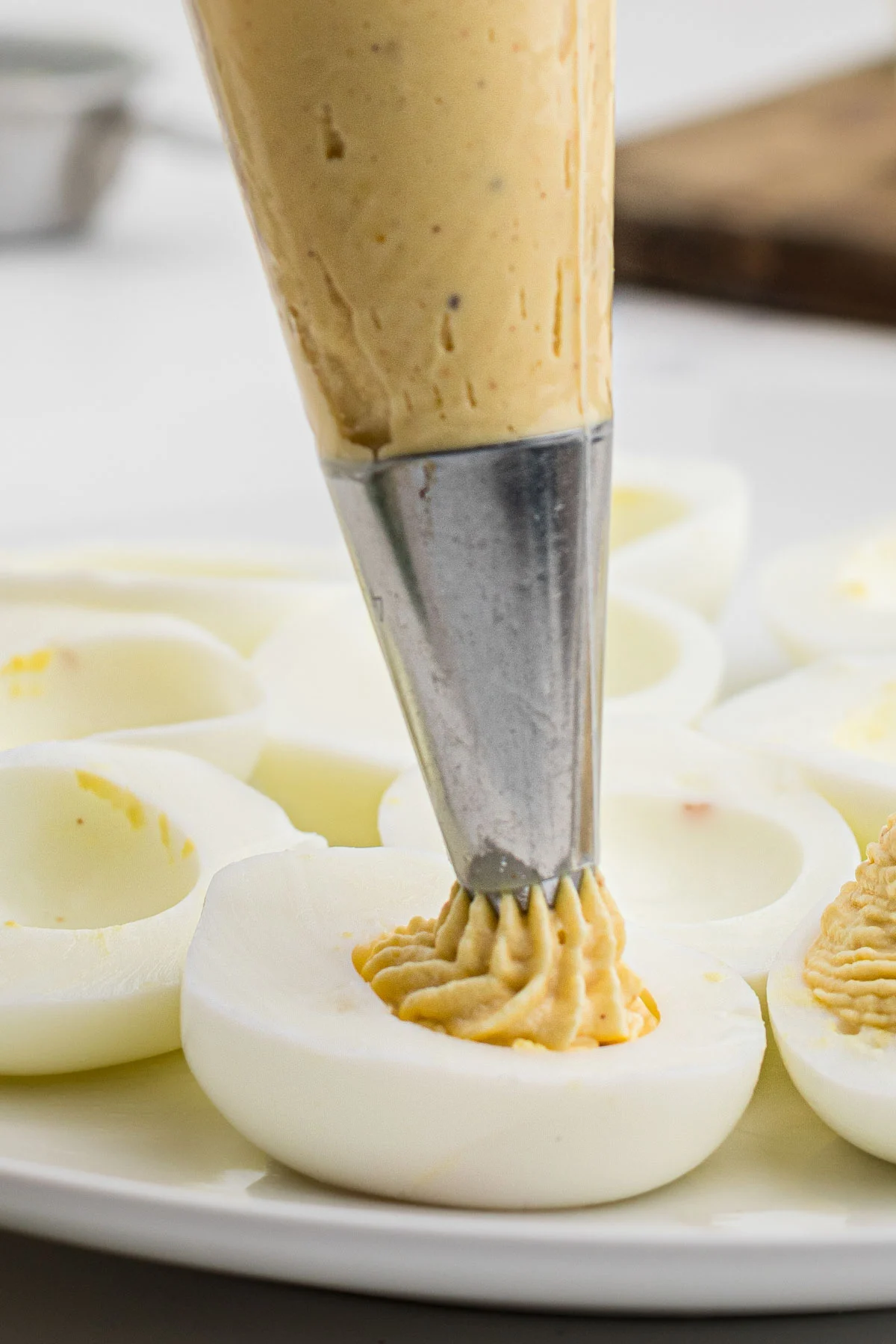 hard boiled egg whites, yolk filling being piped into them.