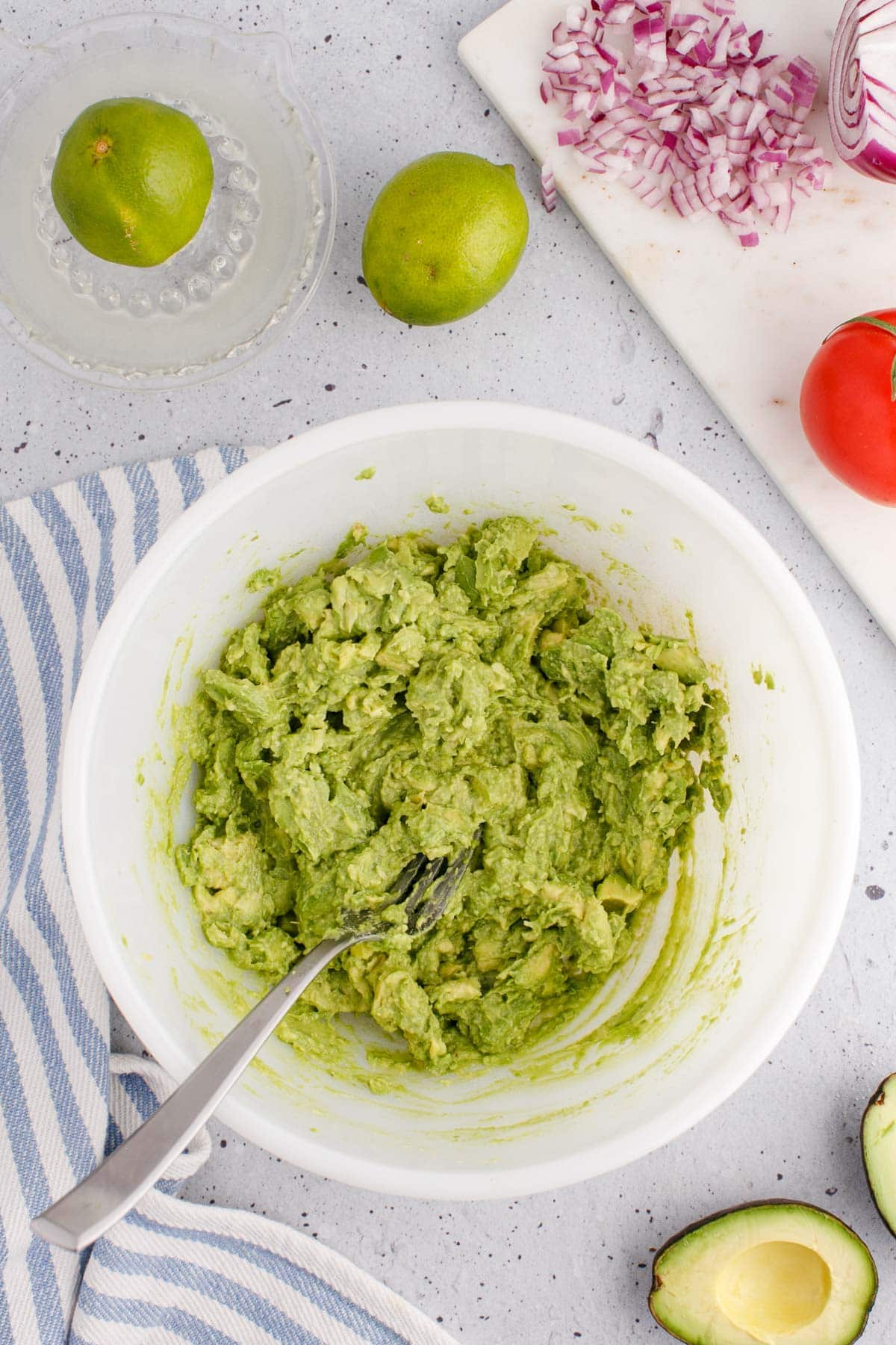 Bowl of mashed avocado with a fork.