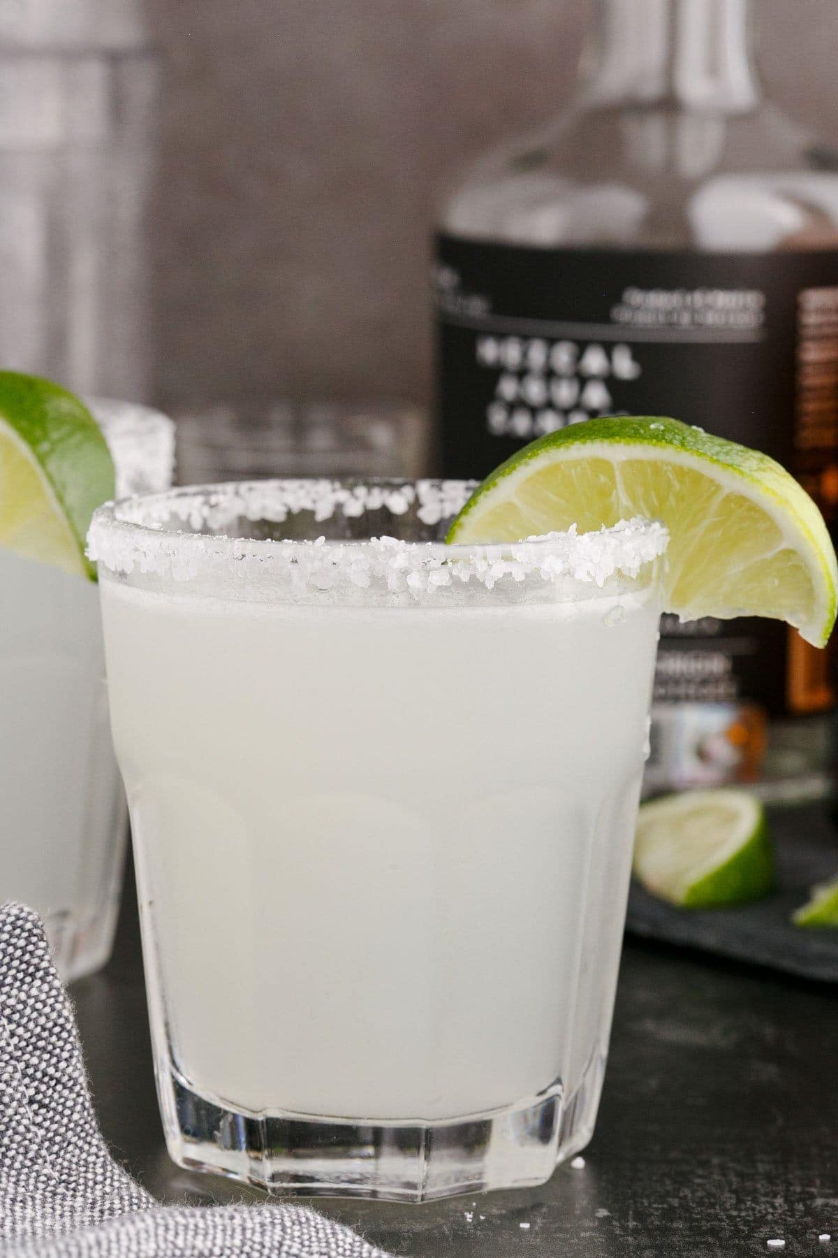 mezcal margarita in a glass with a lime wedge