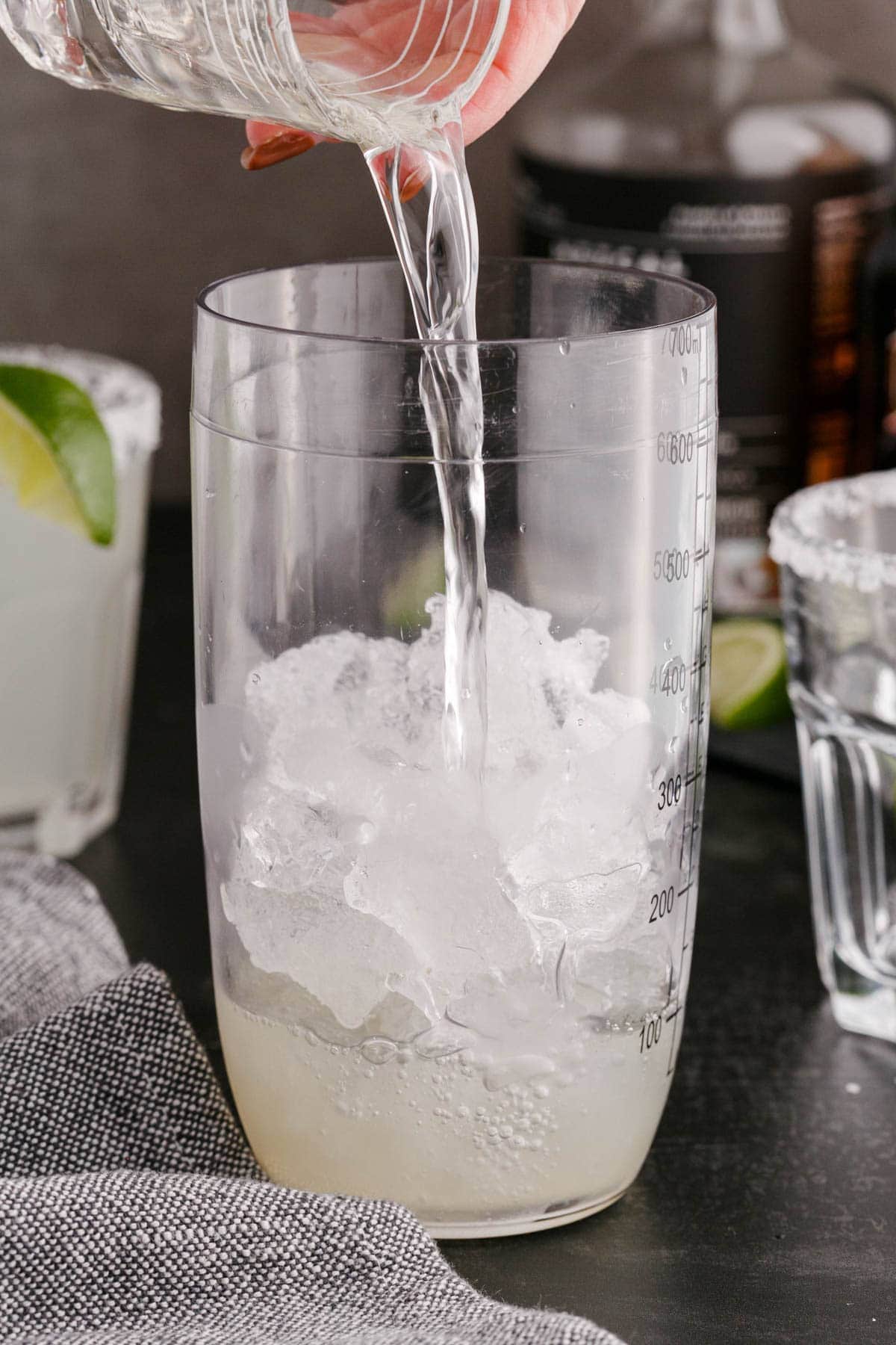 alcohol being poured into a cocktail shaker