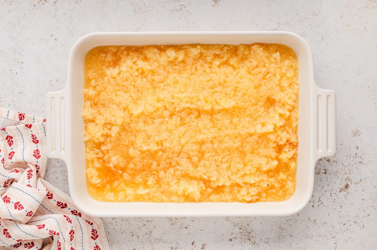 Baking dish with crushed pineapple spread into it.