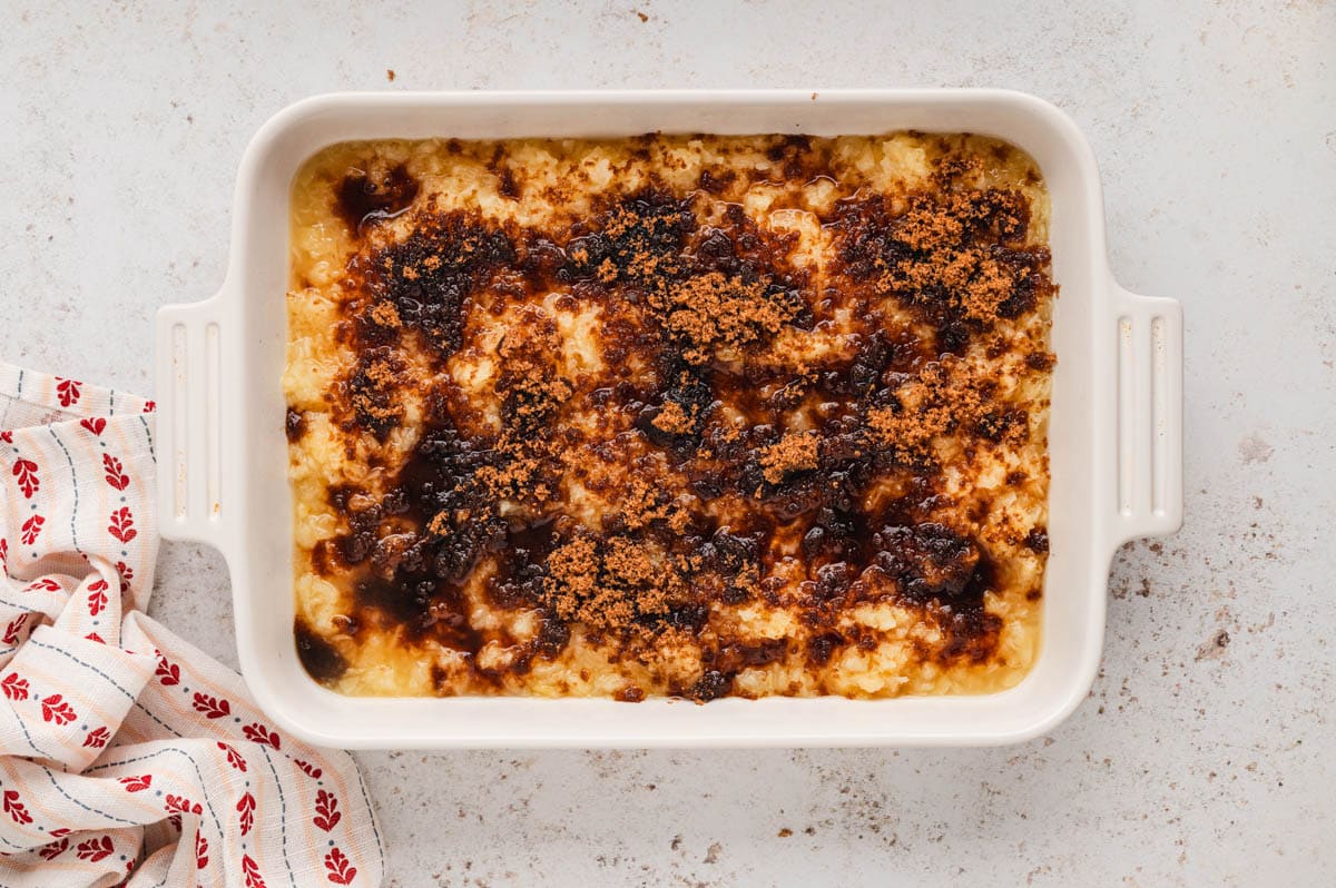 White baking dish with brown sugar sprinkled over crushed pineapple.