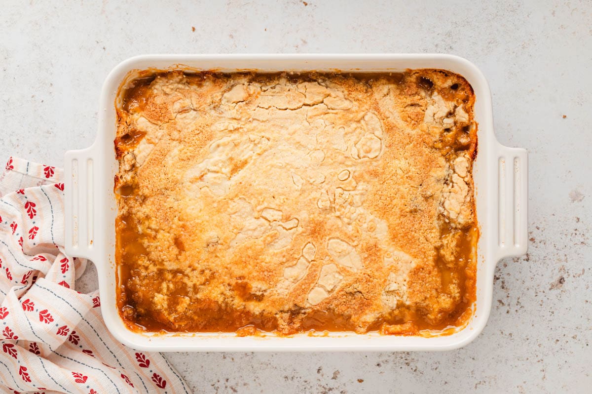 Baked dume cake, golden brown on top, in a white baking dish.