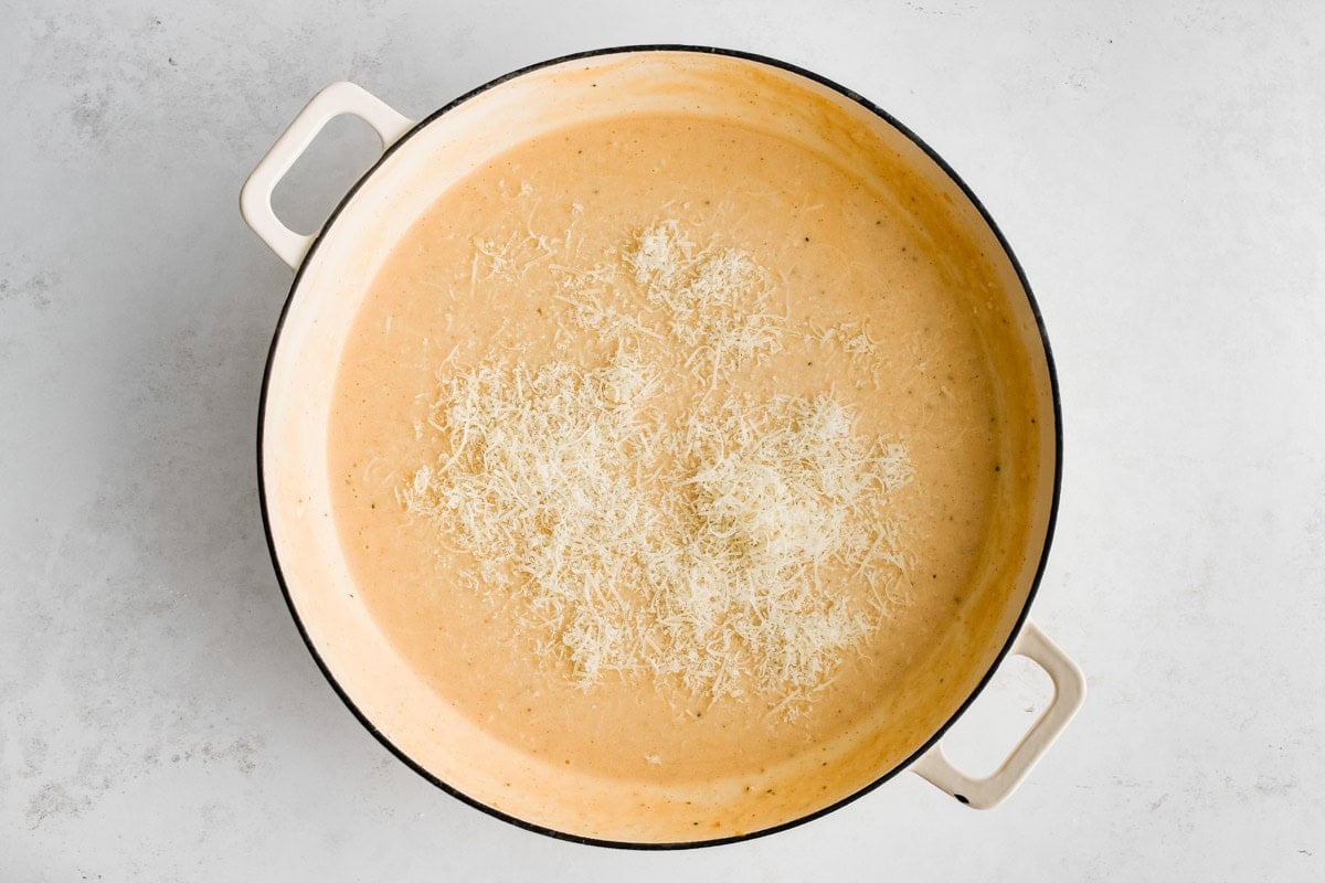 The start of a cheese sauce with a creamy base and parmesan cheese.
