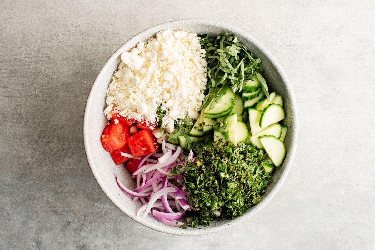 Ingredients for watermelon salad in a bowl.