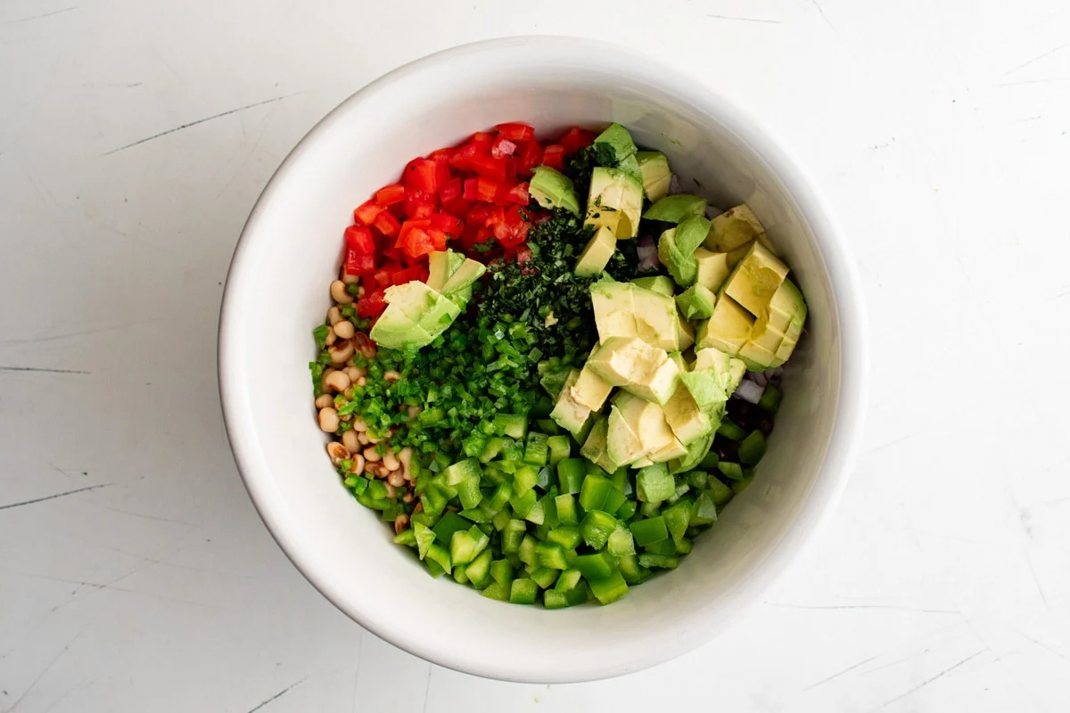 Cowboy caviar ingredients in a white bowl.