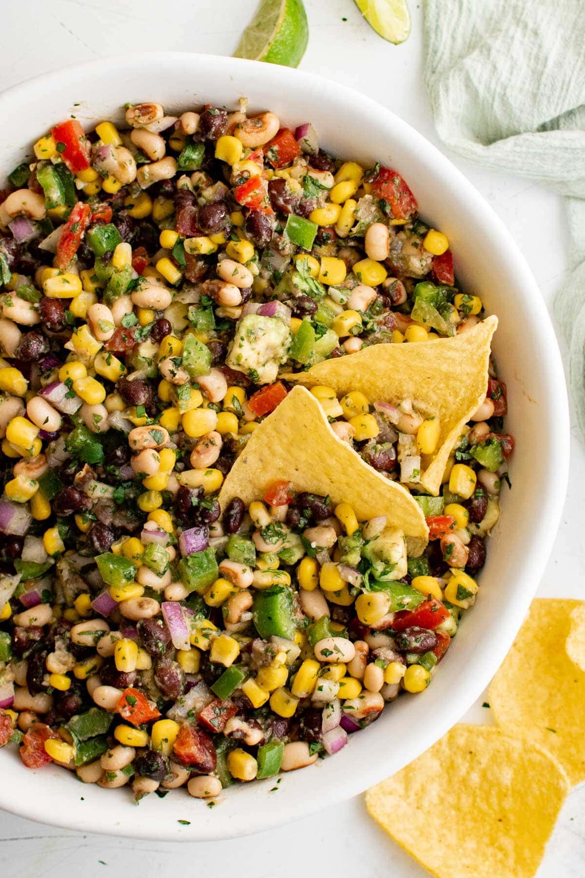 Texas caviar in a white bowl with two tortilla chips.