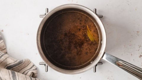Beef stock in a saucepan.