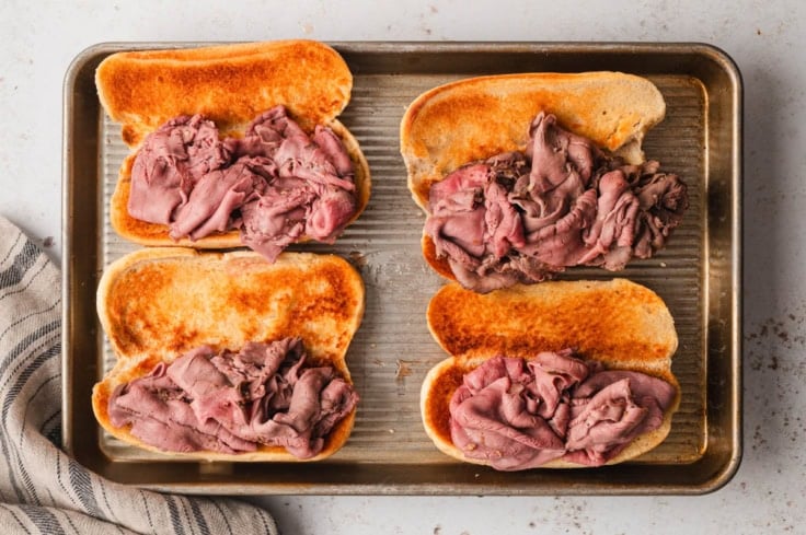 Roast beef on open hoagie rolls.