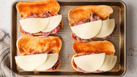 Roast beef and cheese piled onto hoagie rolls.