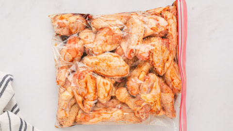 Chicken wings in a plastic bag with marinade.