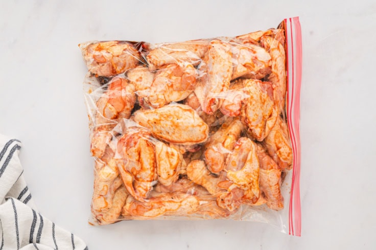 Chicken wings in a plastic bag with marinade.
