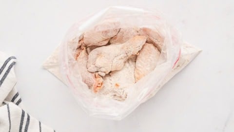 chicken wings in a ziploc bag with flour.