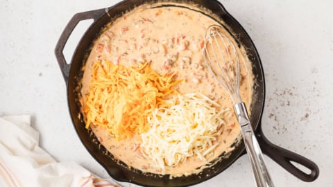 Shredded cheese on top of queso.