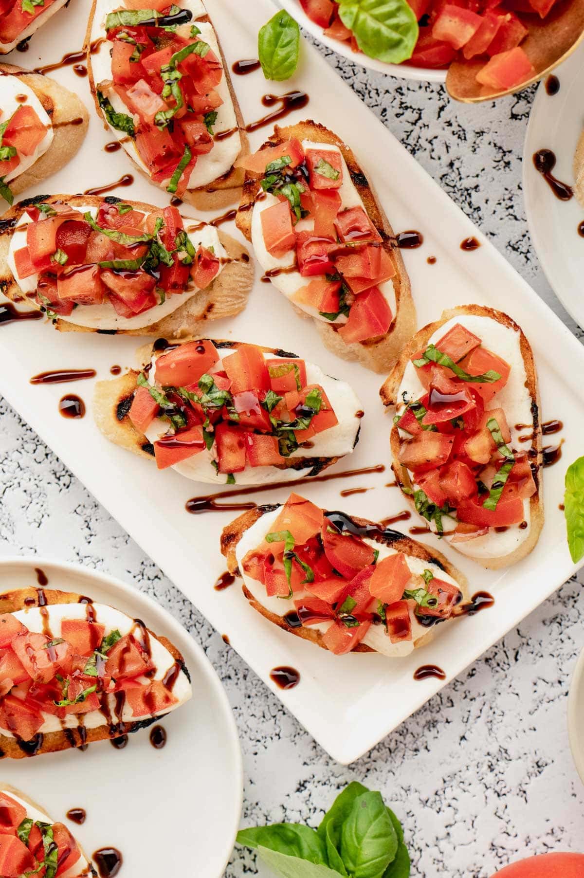 Balsamic glaze drizzled mozzarella bruschetta.