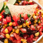 Closeup of corn and black bean salsa with a tortilla chip.