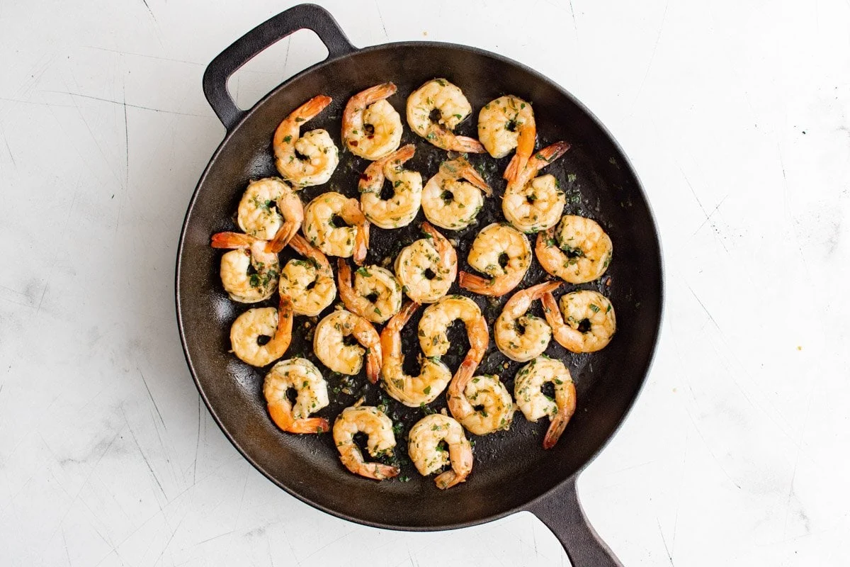 Marinated shrimp in a cast iron skillet.