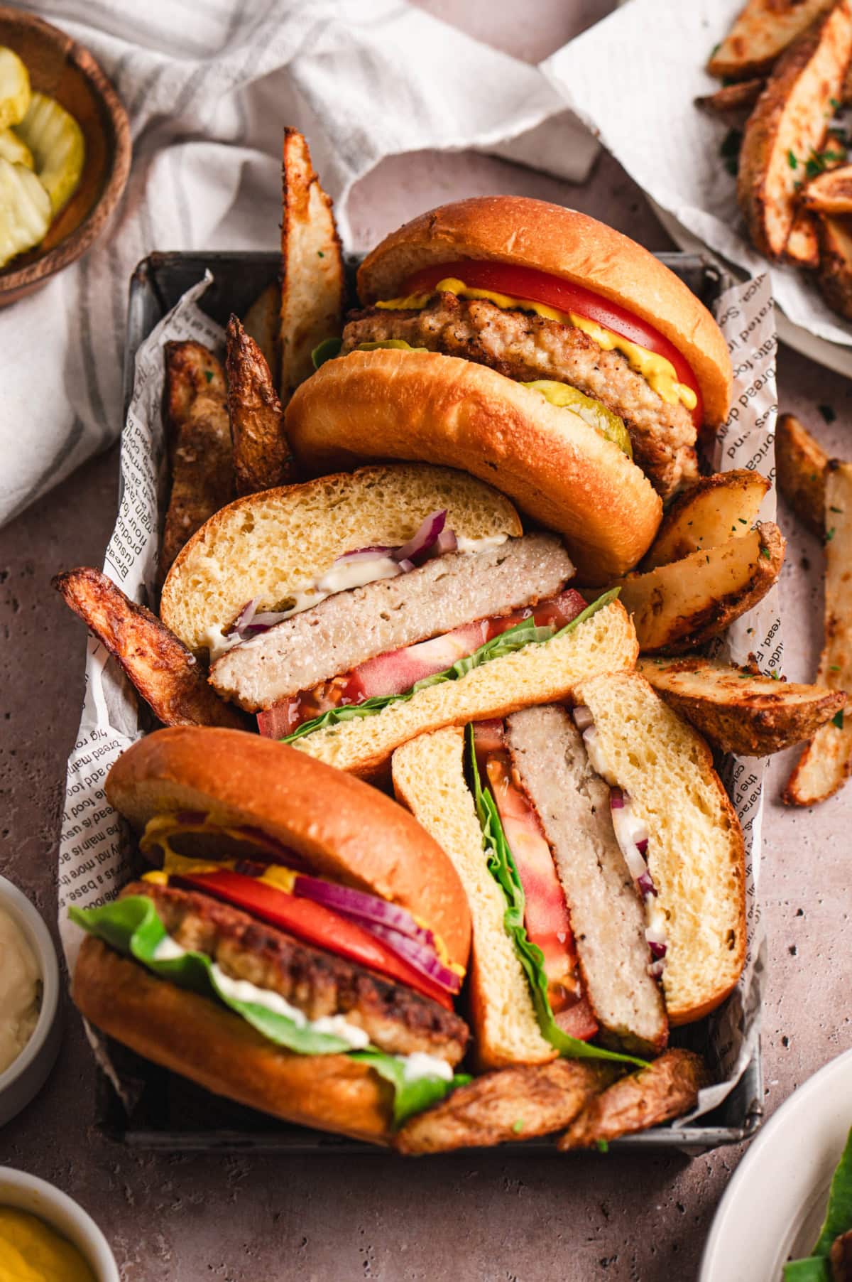 Chicken burgers and potato wedges in a tray lined with paper.
