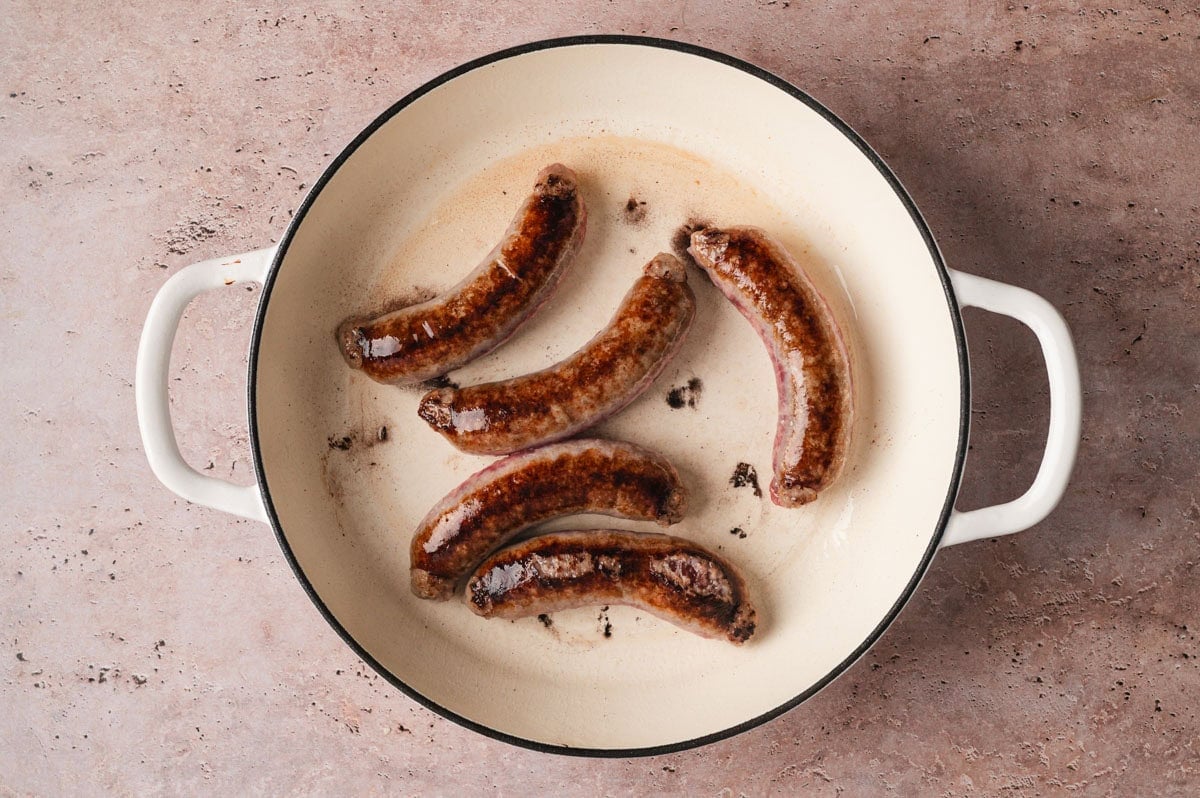 Bratwurst sausages browning in a pan