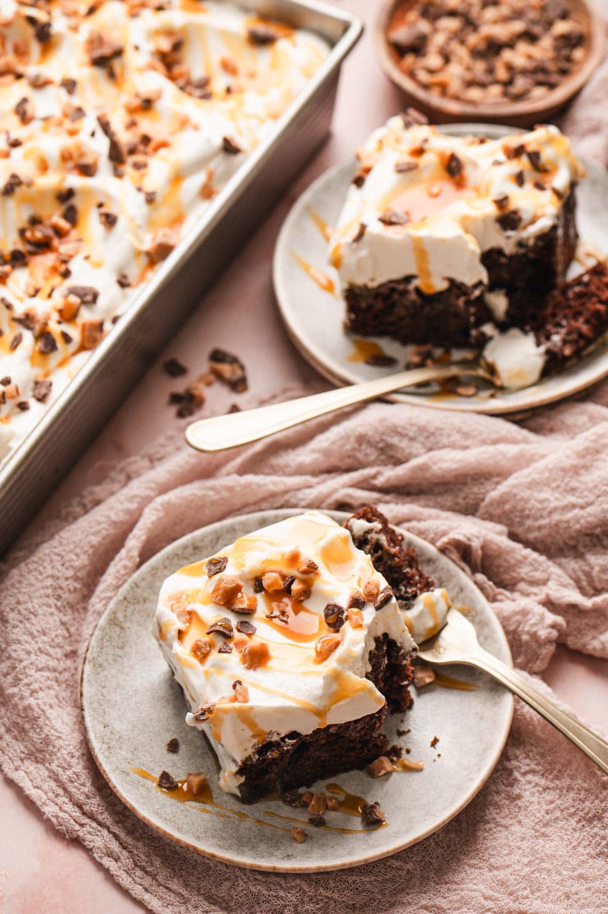 Chocolate cake on a plate with caramel drizzled on top.