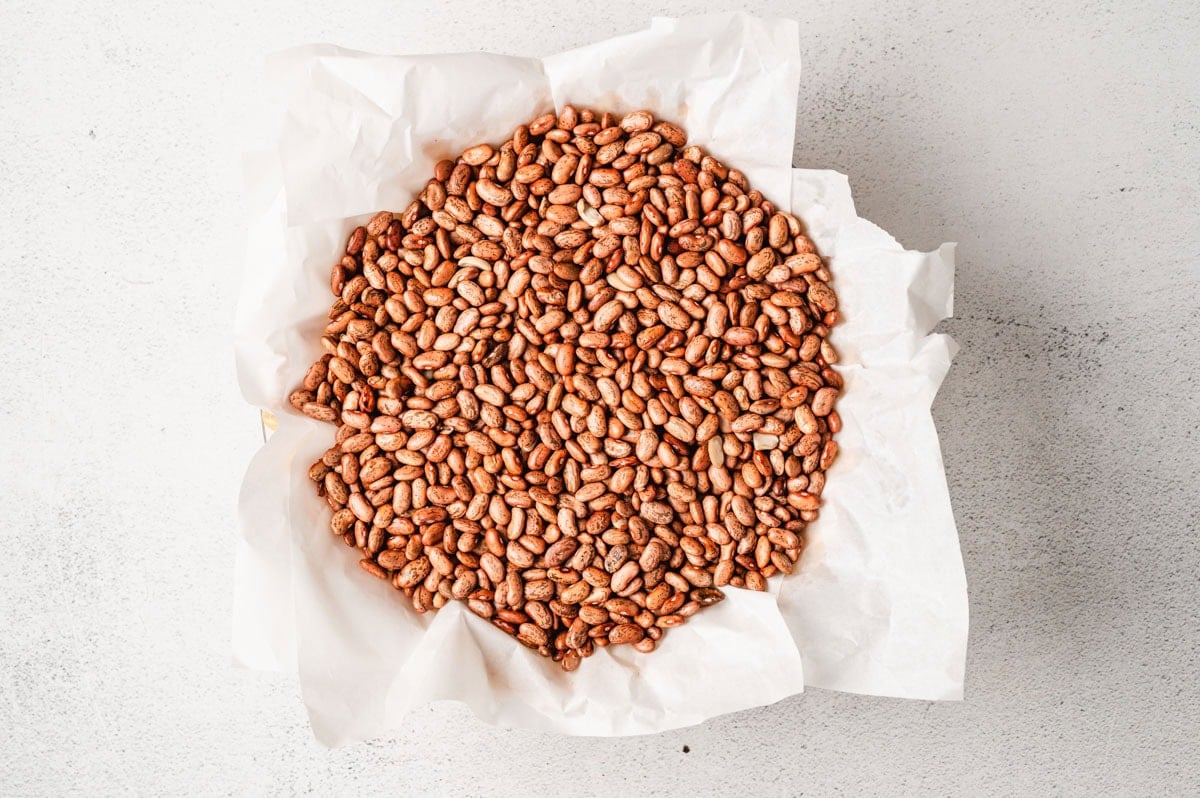 Pie crust lined with parchment paper and filled with beans.