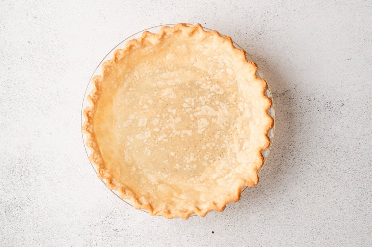 Fully baked pie crust in glass pie dish.