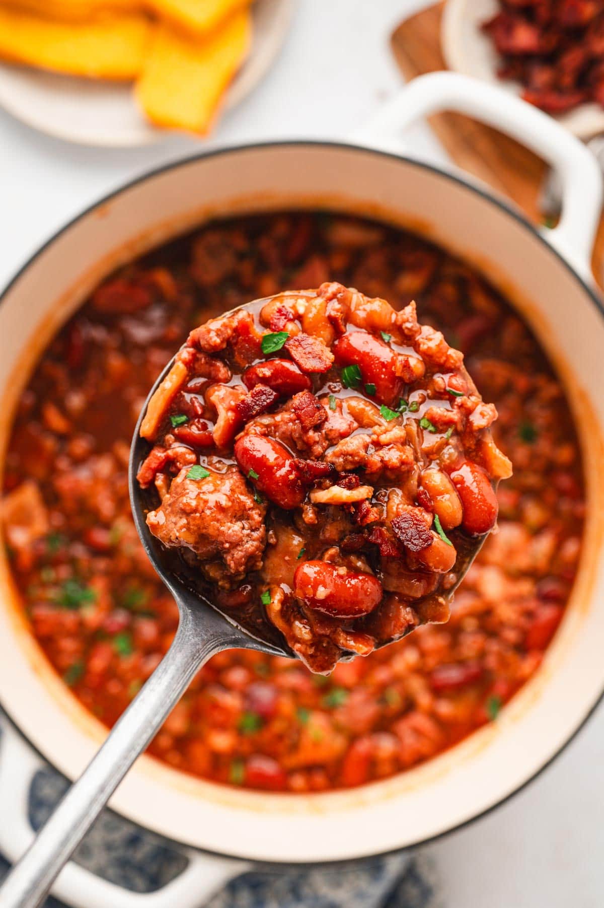 Ladle full of baked beans with beef and bacon.