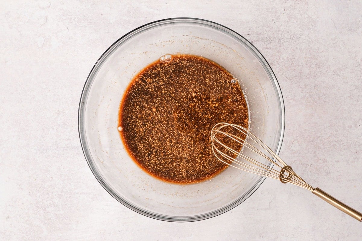 Marinade with a whisk in a glass bowl.