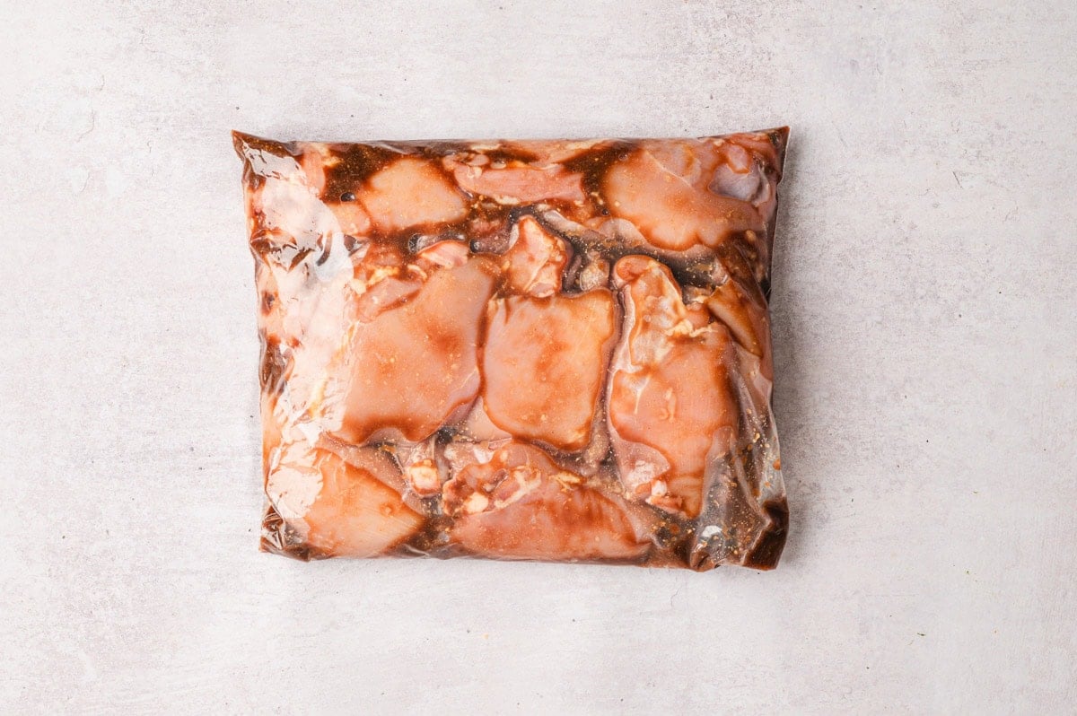 Chicken thighs and marinade in a plastic bag.