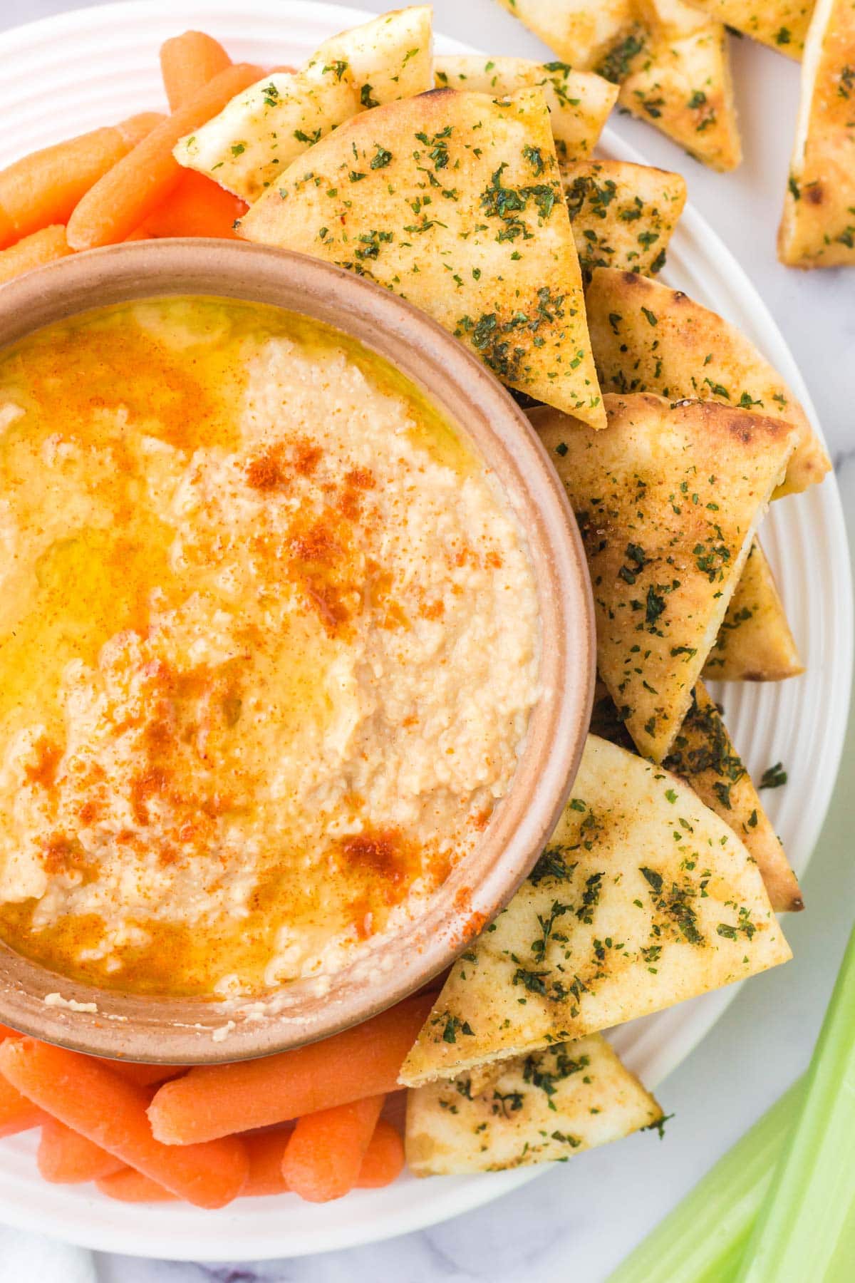bowl of hummus, pita chips and carrots