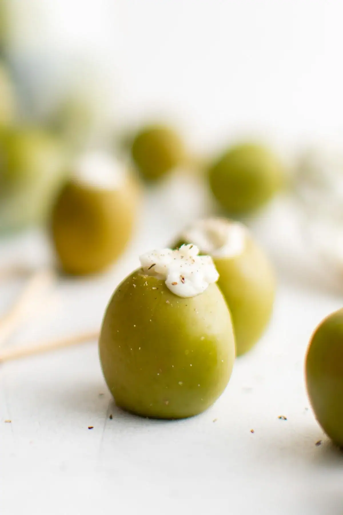 Close up of a green olive with blue cheese stuffing.
