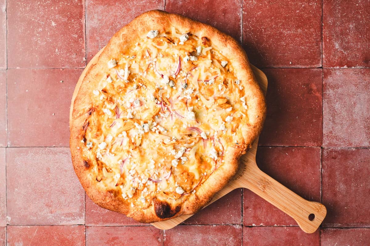 Baked Buffalo Chicken Pizza on a wooden board.