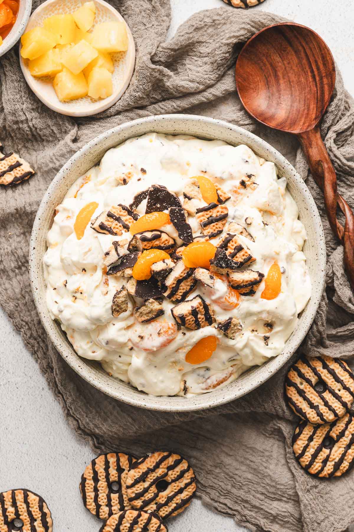 Cookie salad with mandarin oranges and fudge stripe cookies on top in a serving bowl.
