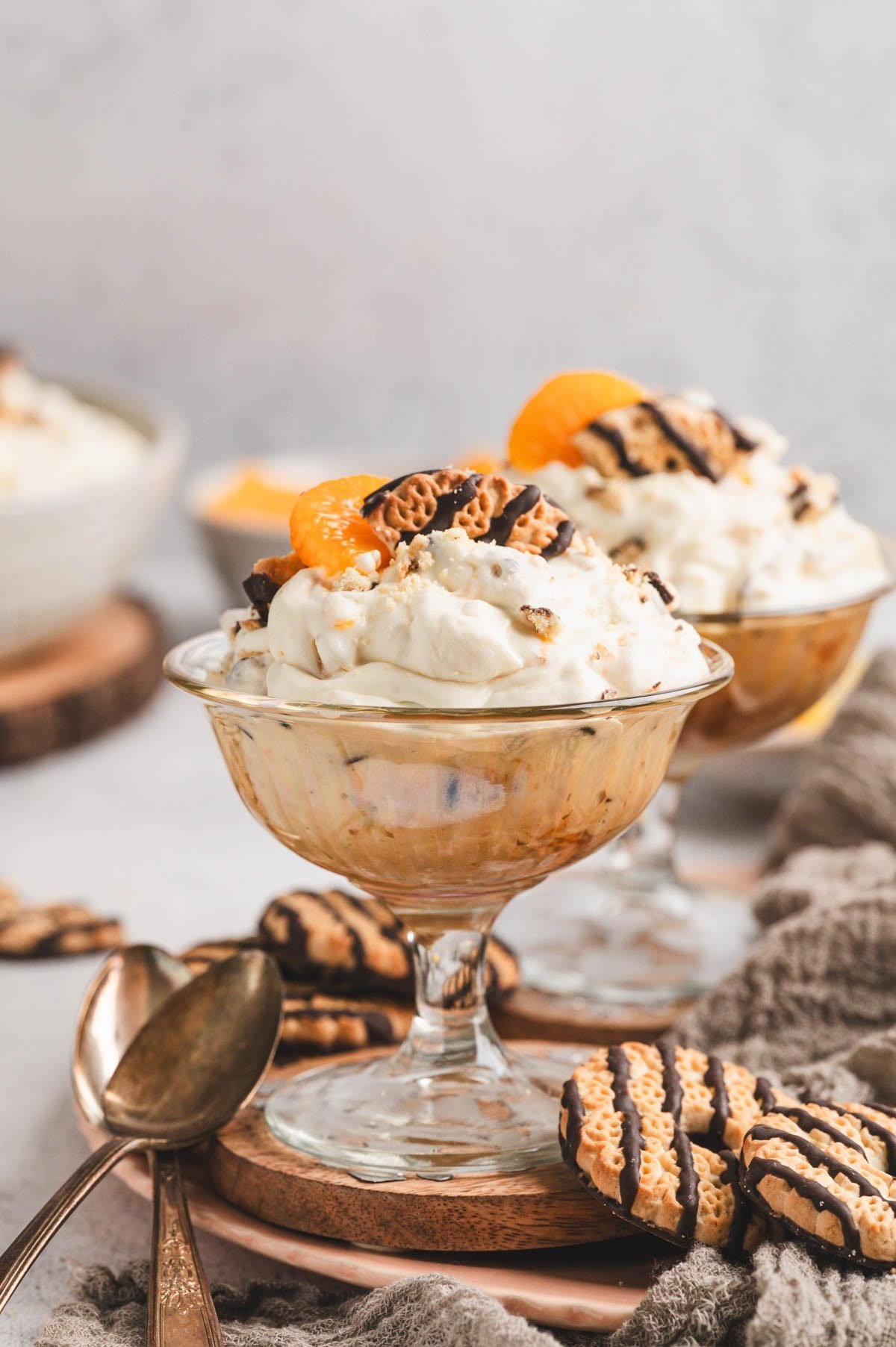 Close up of cookie salad in dessert dishes with fudge strip cookies and mandarin oranges on top.