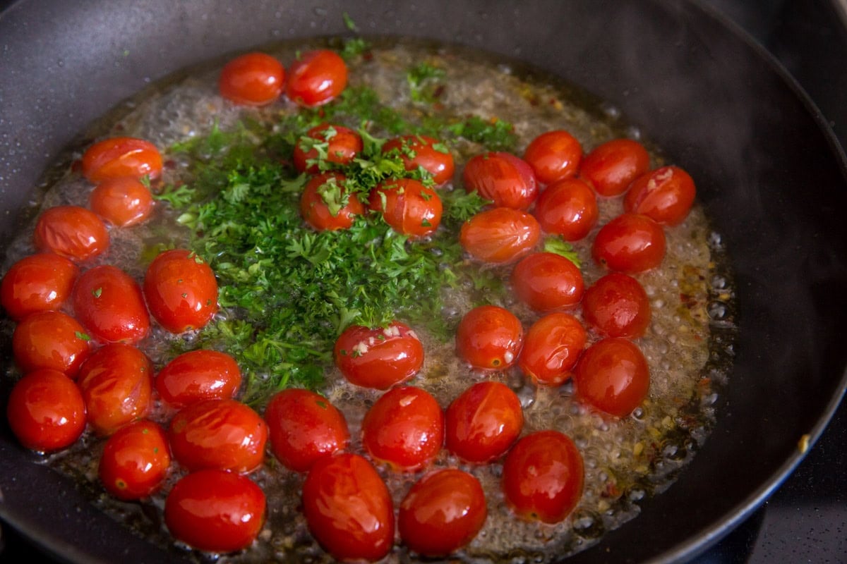 Tomatoes and parsley in a skillet with the olive oil, garlic, and white wine.