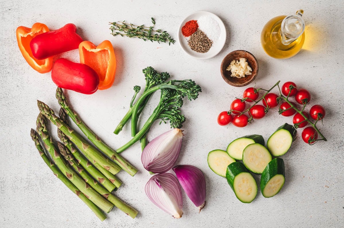 Assortment of vegetables, oil, herbs, and spices.