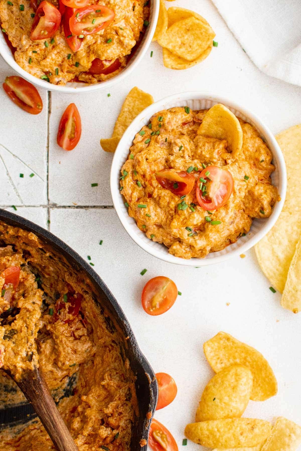 dishes of sausage dip with tomatoes and chips