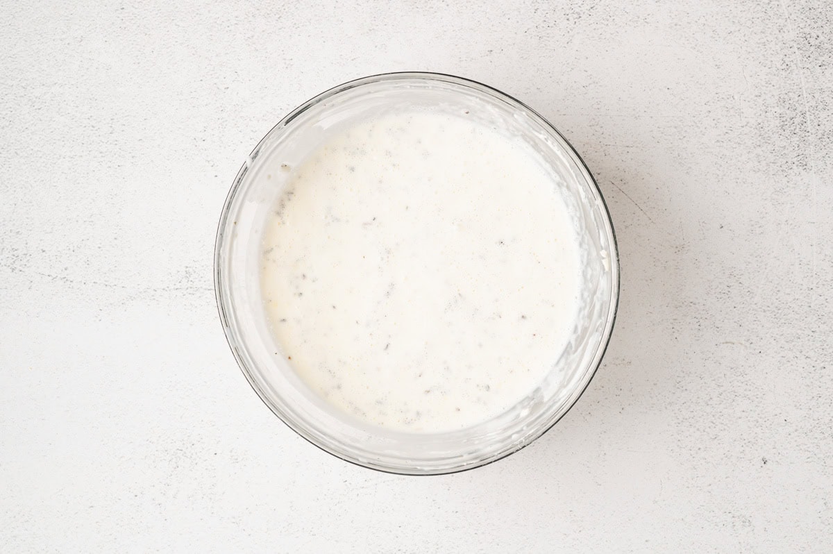 Creamy white pasta sauce in a glass bowl.