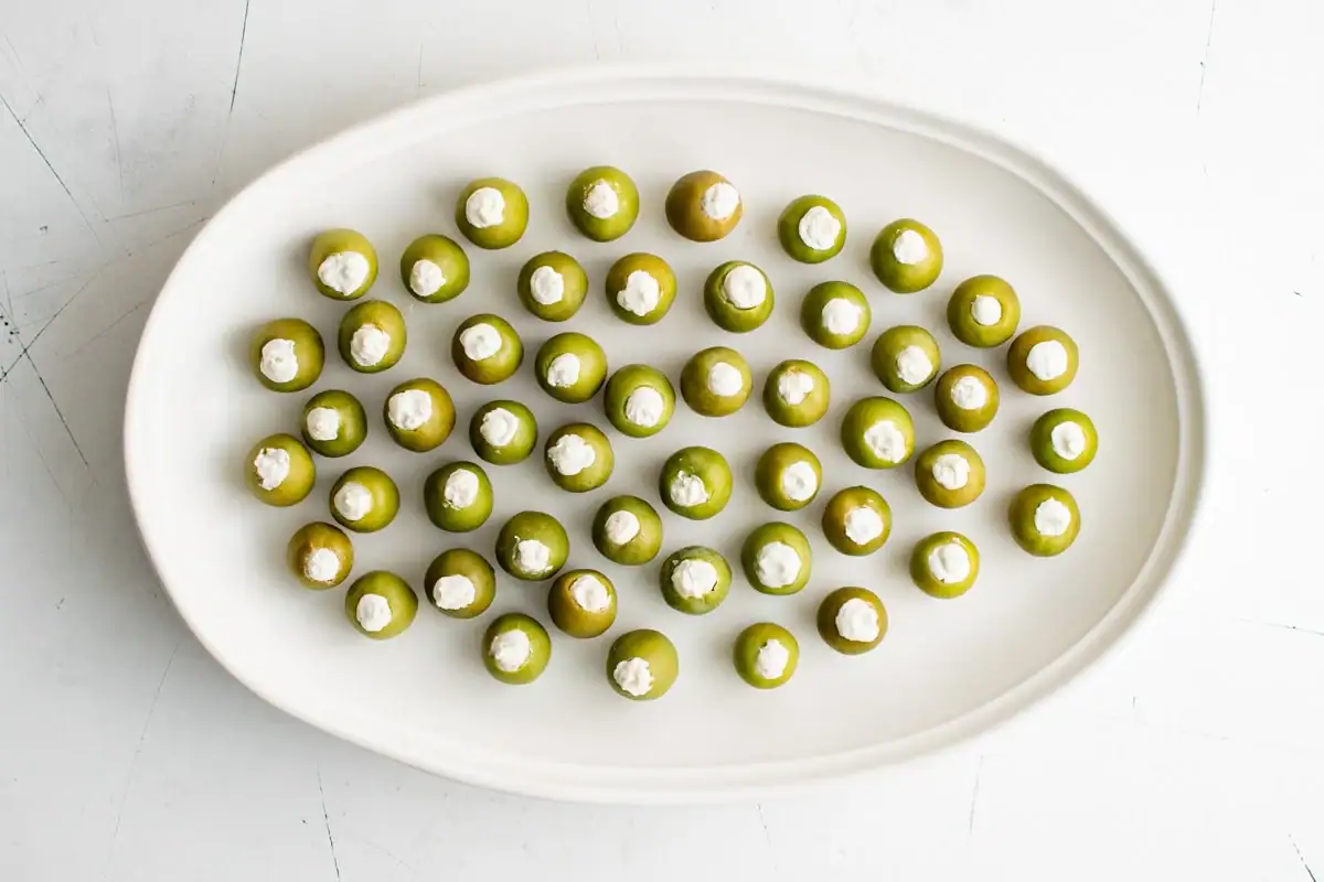 Green olives stuffed with blue cheese on a platter.