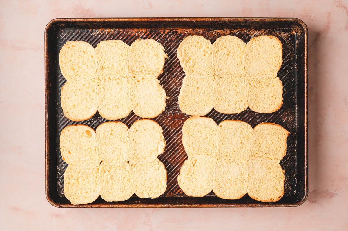 Slider buns on a baking sheet before being toasted.