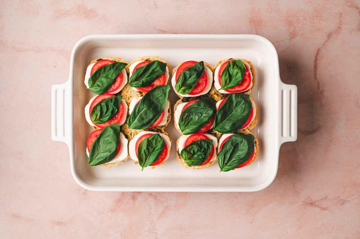 Fresh basil leaves on top of the tomato, mozzarella sliders.