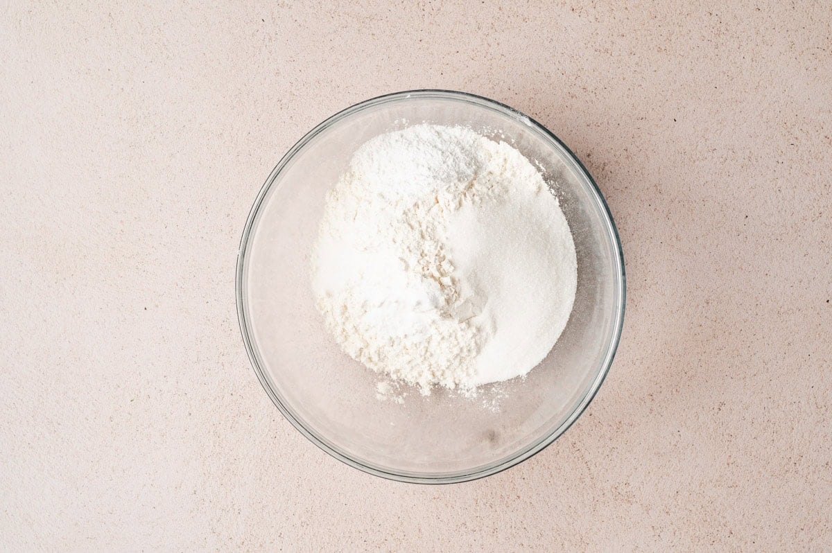 Dry ingredients for buttermilk pancakes in a large glass bowl before being mixed.