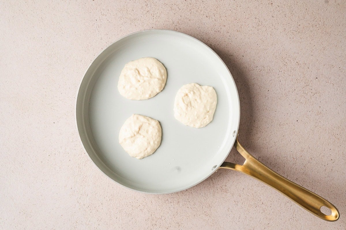 Pancake batter on a skillet before being flipped.
