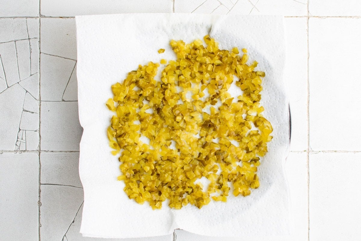 Chopped pickles on a paper towel draining. 