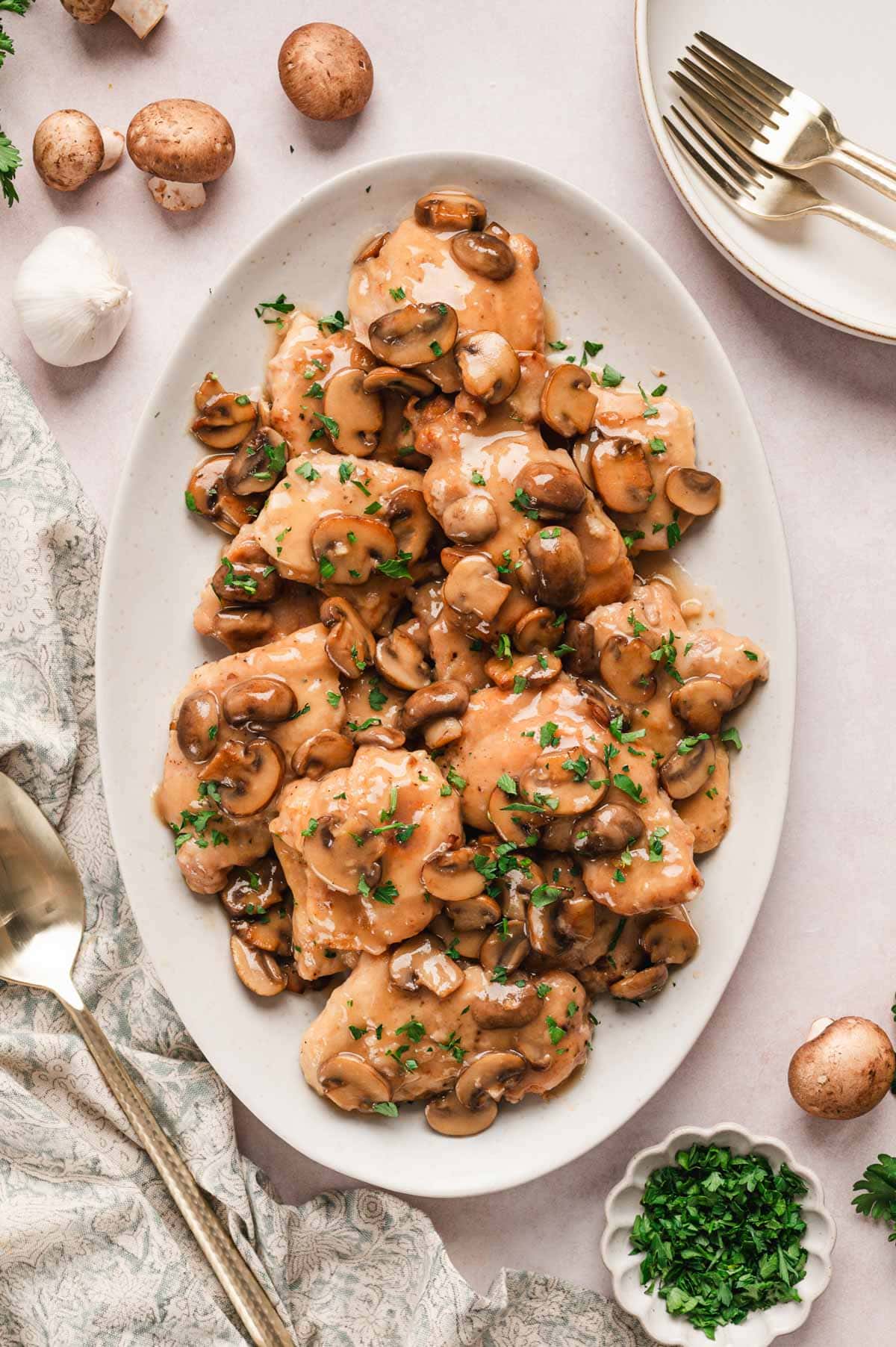 Chicken marsala with mushrooms on a white platter.