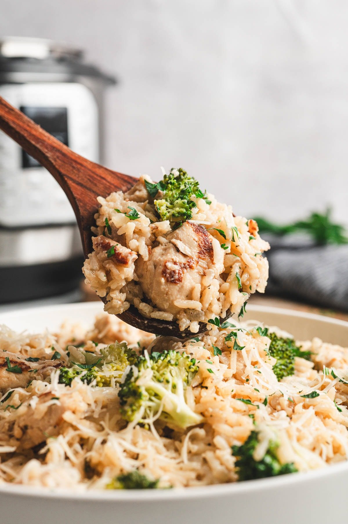 Instant Pot Chicken and Rice with broccoli being scooped out with a large wooden spoon.