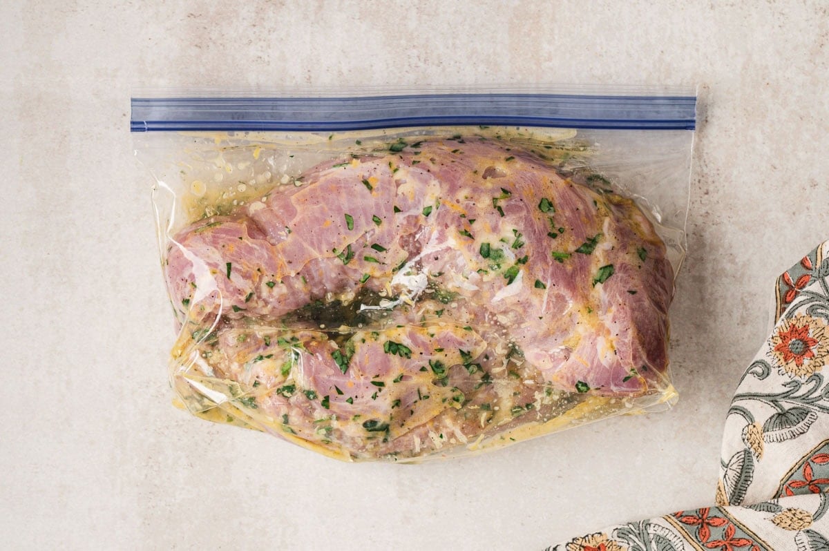 Raw pork tenderloins in a plastic bag with marinade.